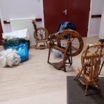 A selection of small spinning wheels with raw wool.